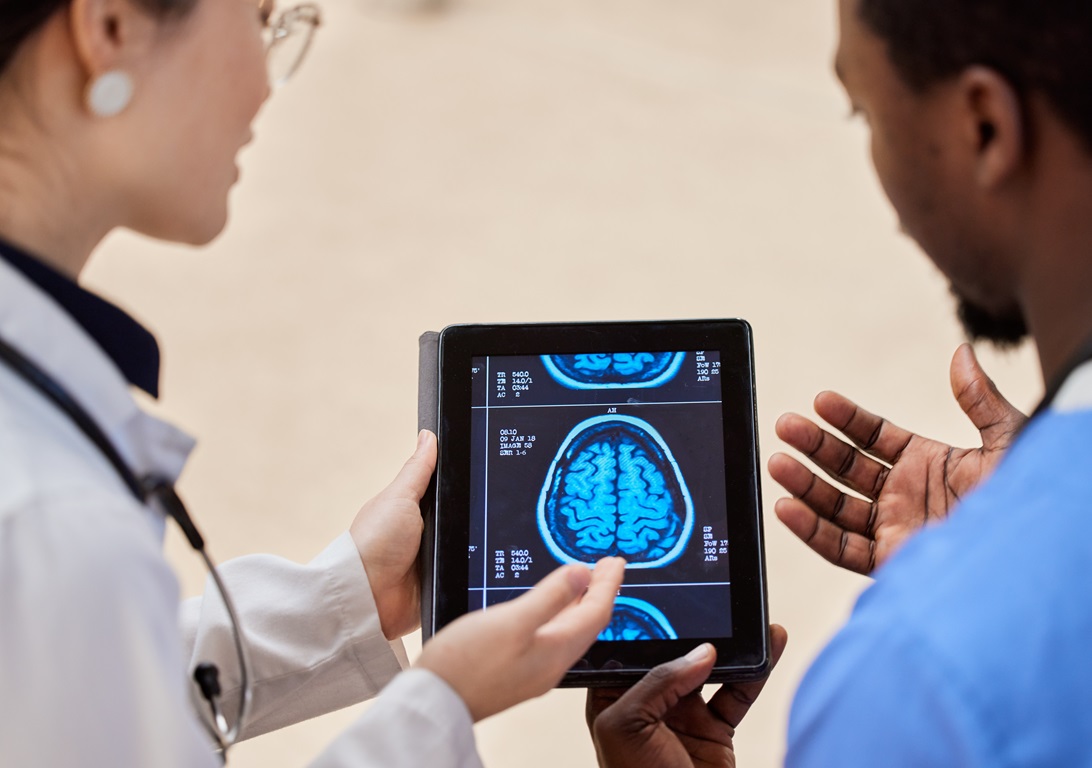 Tablet, cancer or x ray of the brain with a doctor and nurse talking in a hospital for diagnosis