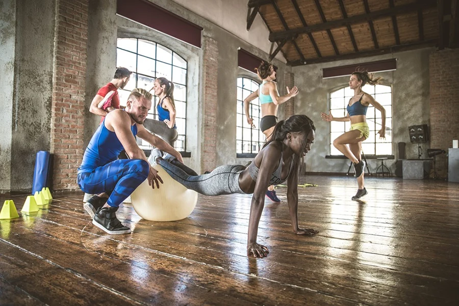 Multi-ethnic group of people training in a gym - Personal  trainer and sportive persons  in a fitness class